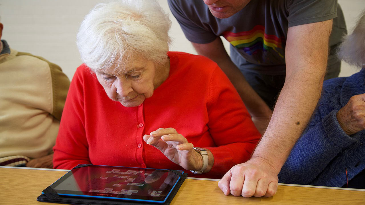 eldery woman using ipad with help