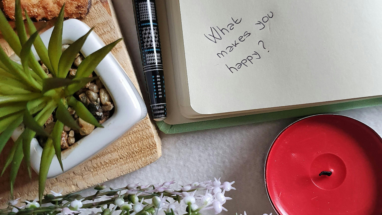 notebook, plant, and candle on a table