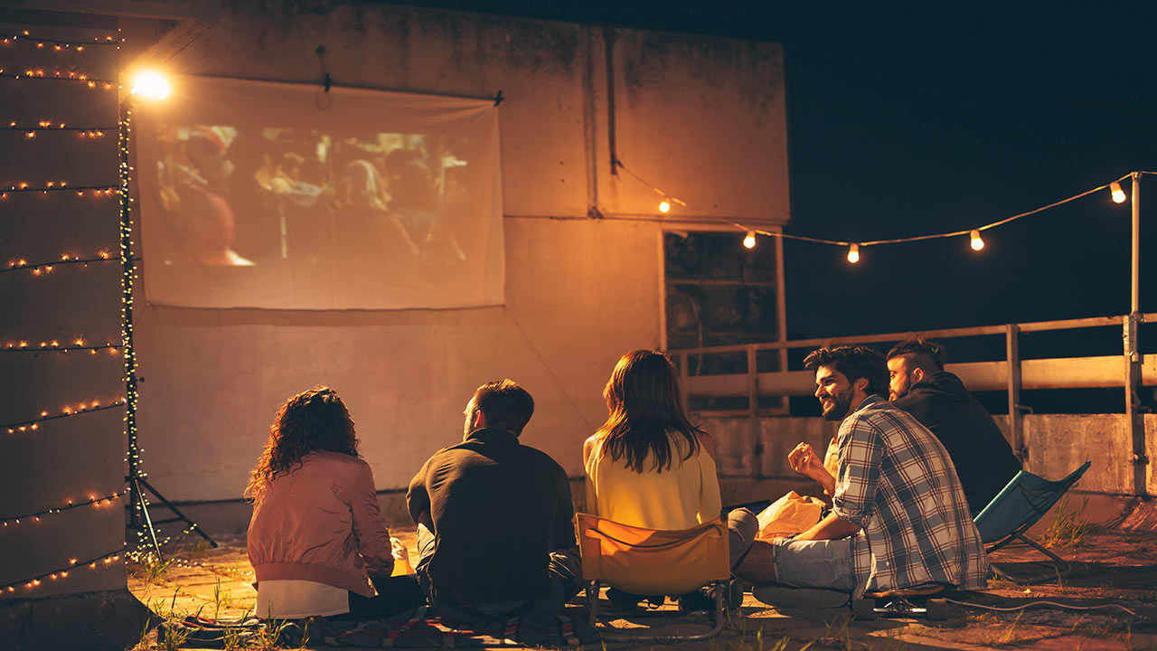 group of friends watching a movie outside