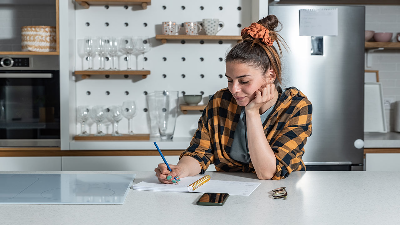 young woman planning a menu in kitchen